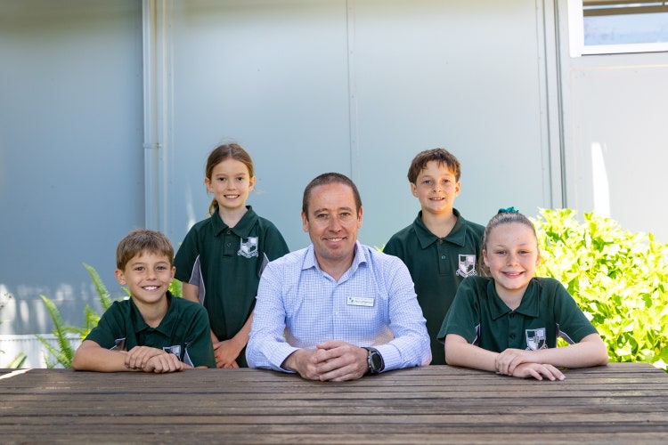 The Principal and 4 students sitting a picnic table