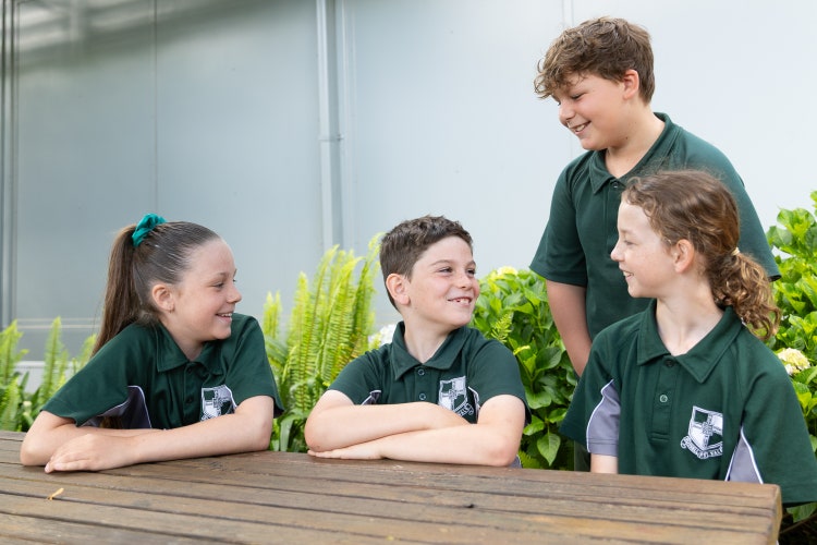 4 students sitting at a picnic table